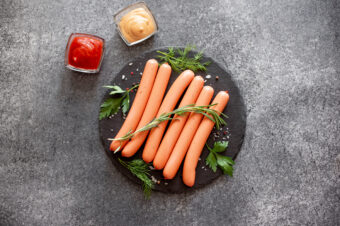 Raw,Sausages,On,Stone,Background