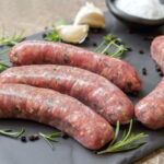 Raw,Sausages,On,Slate,,With,Herbs,And,Spices.,Side,View.