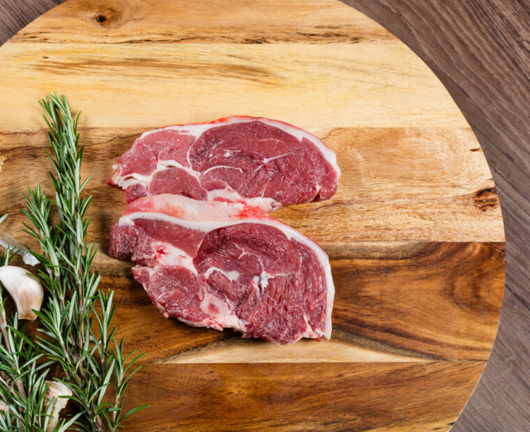 Raw,Lamb,Chump,Slices,On,Chopping,Board,With,Herbs