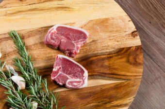 Raw,Lamb,Loin,Slices,On,Chopping,Board,With,Herbs