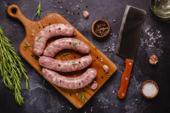 Raw,Sausages,And,Ingredients,For,Cooking,On,A,Black,Stone