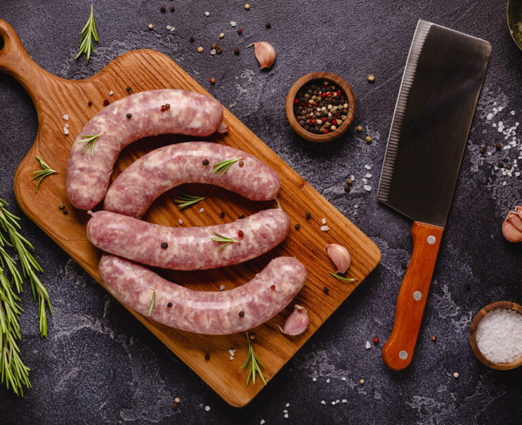Raw,Sausages,And,Ingredients,For,Cooking,On,A,Black,Stone