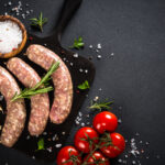 Bratwurst,Or,Sausages,On,Cutting,Board,With,Spices,At,Black