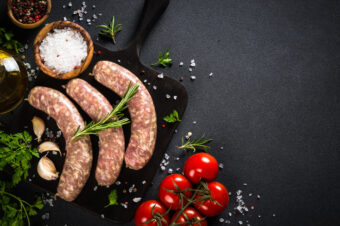 Bratwurst,Or,Sausages,On,Cutting,Board,With,Spices,At,Black