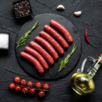 Raw,Beef,Sausages,On,Stone,Background
