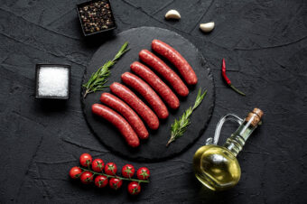 Raw,Beef,Sausages,On,Stone,Background