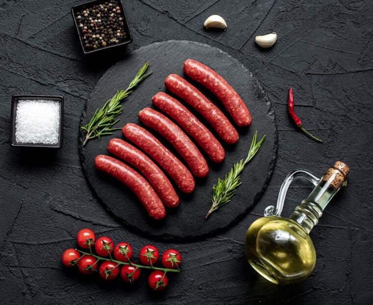 Raw,Beef,Sausages,On,Stone,Background