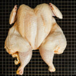 Whole,Raw,Chicken,On,Metal,Rack