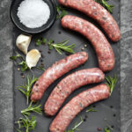 Raw,Sausages,On,Slate,,With,Herbs,And,Spices.,Overhead,View.